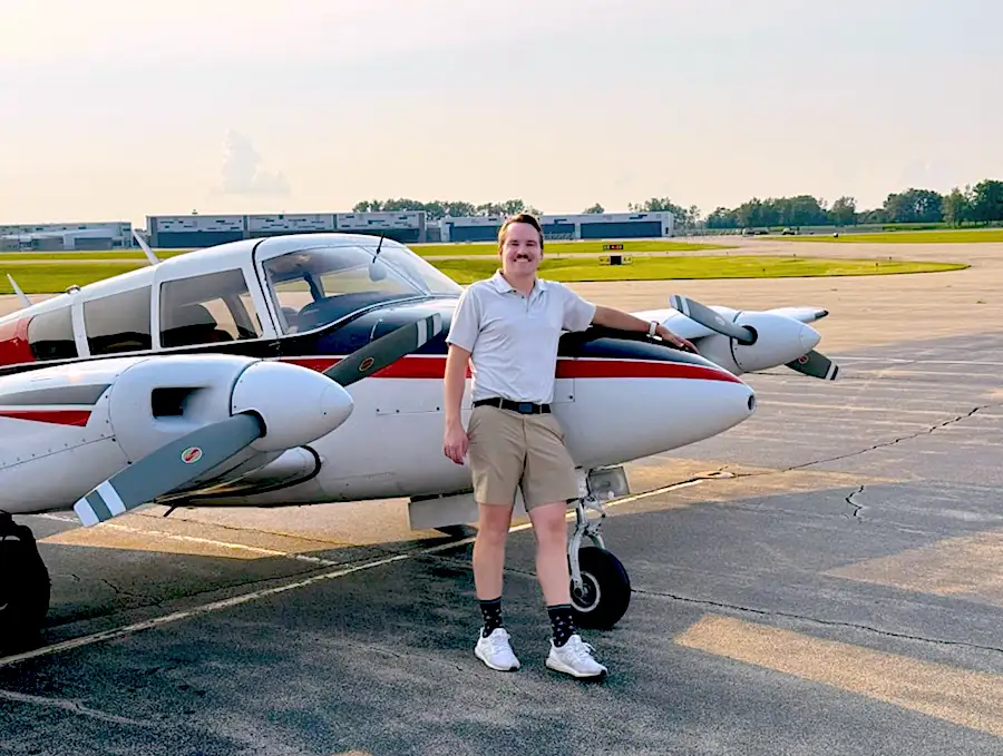 Elite Flight Training student by a multi-engine airplane